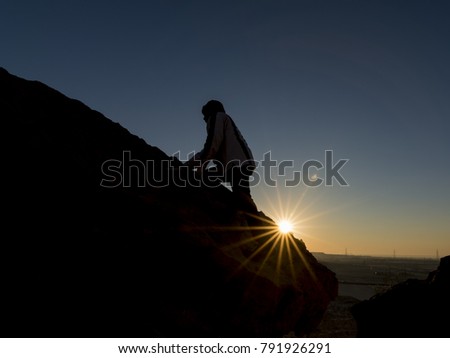 Silhouette of a traveler tourist exploring the rocky landscapes at sunrise