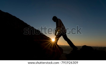 Silhouette of a traveler tourist exploring the rocky landscapes at sunrise