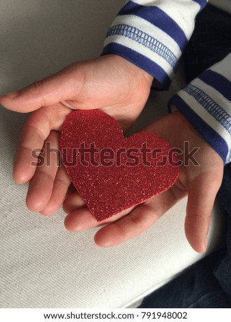Child holding a sparkly heart in his hands