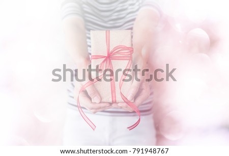 present given from woman's hands on special occassion with bokeh background