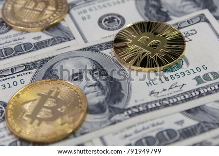  golden bitcoins and litecoin on background of one hundred dollar bills