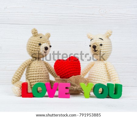 Sweet couple teddy bear doll in love with Love text and red knitting heart on white wooden background and copy space for add text and picture, love and valentine day concept idea.