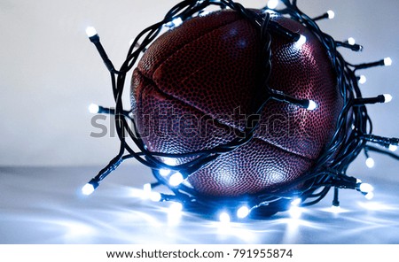 The led decoration lights are wrapped around the American football ball on the white background