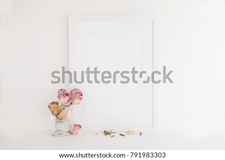 A4 A3 picture frame on white background next to dry roses with negative space for overlay, quote, work or your logo. Blogger and website designers tool for marketing and promotion.
