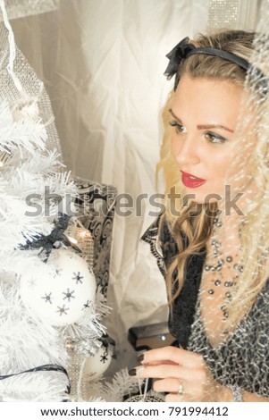 Young beautiful woman on Christmas tree black and white decoration