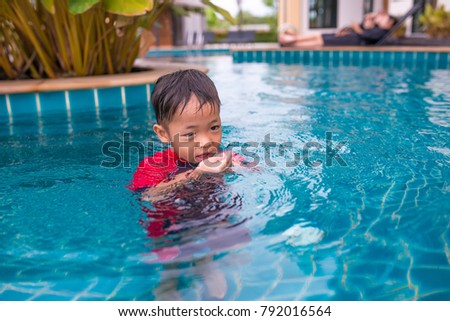 Asian child plays in the water.