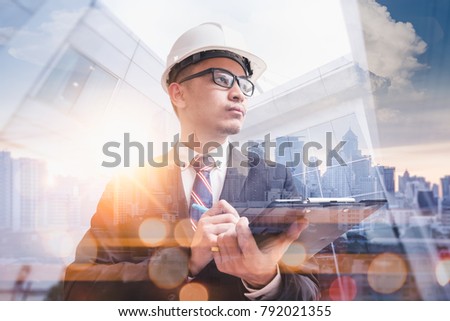 the abstract image of the engineer writing on writing pad during sunrise overlay with cityscape image. the concept of engineering, construction, city, double exposure and technology.