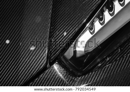 Luxury Italian sports car fragment, headlight mounted in carbon fiber body parts