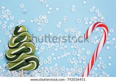 Christmas tree, sugar cane lollipop on a blue background. New Year's picture.