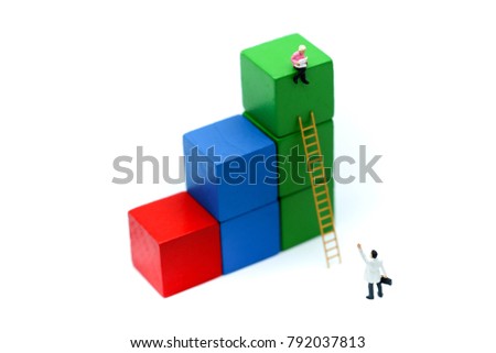 Miniature people : Businessmen standing with ladder graphs rise from business profits. Using as business concept.