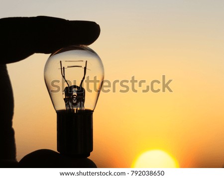 Silhouette picture of the Fluorescent in  fingers with blurred sunlight Background.