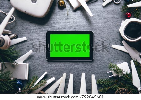 Drone equipment, tablet green screen key on the background of a dark wooden table. Aerial shooting concept. best christmas tree new year present gift.
