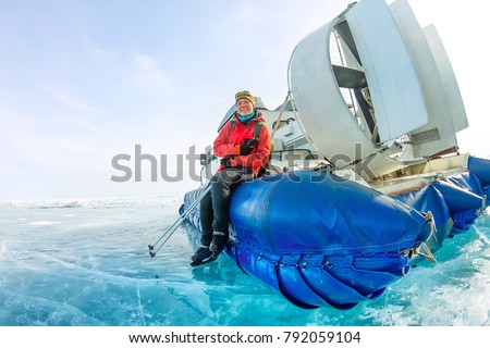 girl sits on the board hovercraft ice winter lake Baikal.