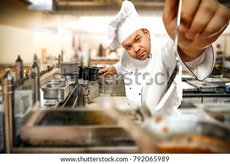 Cook chef in kitchen interior. Blurred kitchen tools. Crazy guy. 