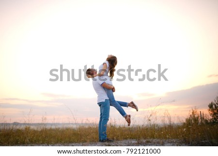 Loving young couple at sunset in the evening on a blurry beautiful background