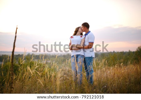 Loving young couple at sunset in the evening on a blurry beautiful background