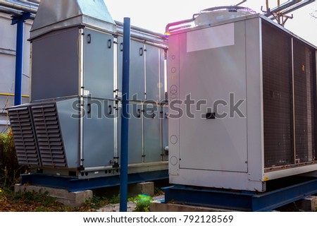 Industrial air handling unit with DX coil with big condensing unit standing outdoor on the ground covered by fallen leaves Royalty-Free Stock Photo #792128569