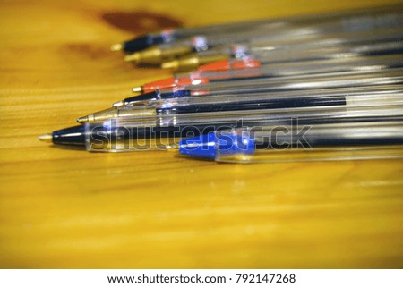 Set of colorful pens laying on old table.