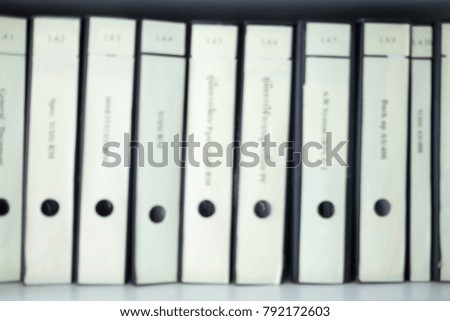 Blurred image of file folders on the shelf in office.