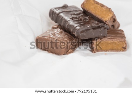 CHOCOLATE BARS WITH TOFFEE CARAMEL ON WHITE NAPKIN (COPY SPACE)