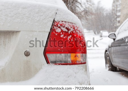 Snow covered car tail light closeup. Car in winter