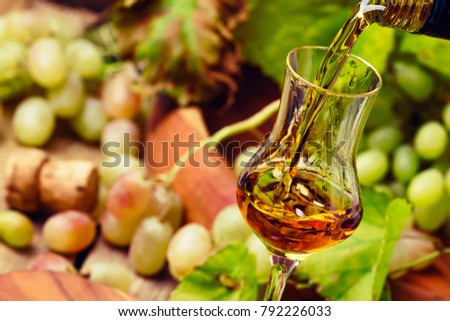 Golden Grappa Being Poured Into Shot Glass, Rustic Still Life, Selective Focus Royalty-Free Stock Photo #792226033