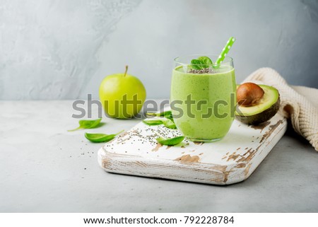 Vegetarian healthy green smoothie from avocado, spinach leaves, apple and chia seeds on gray concrete background. Selective focus. Space for text. Royalty-Free Stock Photo #792228784