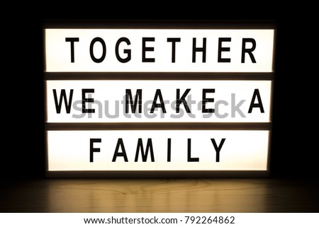Together we make a family light box sign board on wooden table. 