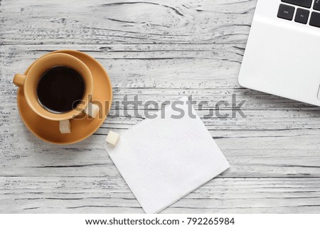 Background of a valentine on a wooden table with a laptop cup of coffee hearts beside a napkin for writing. Valentine's Day.
