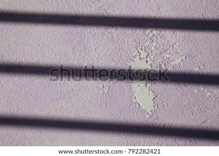 Abstract picture made of shadow lines and old purple wallpaper with white spots. Geometric design with parallels elements and a textured surface. Vintage peace of paper lighted by the sun.  