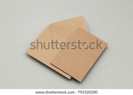Blank brown kraft paper card and envelope on a grey background