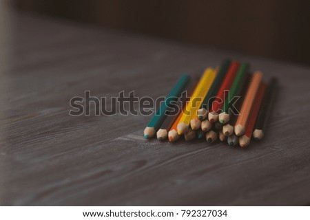 colored pencils on a dark wooden background