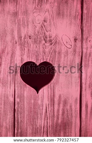 Heart carved in a red wooden board. Background.