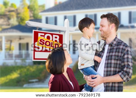 Young Mixed Race Caucasian and Chinese Family In Front of Sold For Sale Real Estate Sign and House.