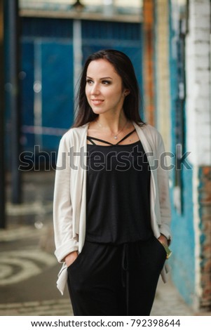 A brunette woman is walking around the city