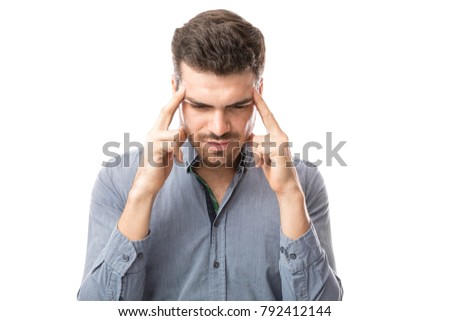 Young man touching his temples and trying to focus on a white background