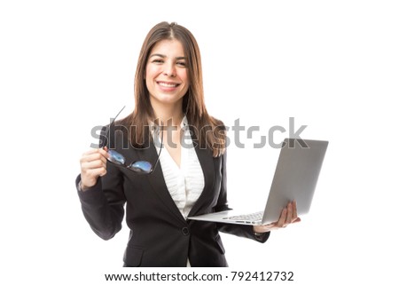 Good looking Hispanic woman wearing a suit and holding a laptop computer while working for tech support