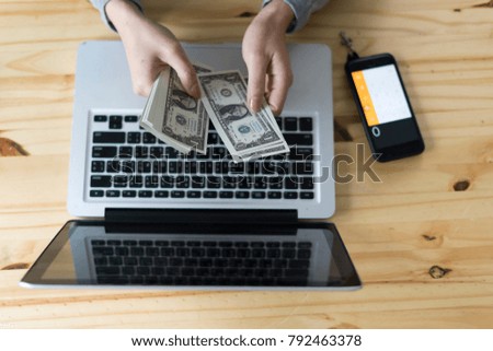 selective focus Business girl counting money with laptop and smart phone on wooden table  online business concept 