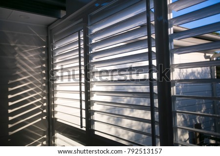 Triple outdoor white windows aluminium louver shutter at the house back yard sun room  Royalty-Free Stock Photo #792513157