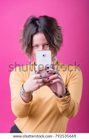 Cute trendy girl taking a picture of you with her cell phone
