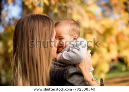 Portrait of young mother and baby boy in autumn park