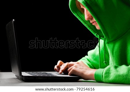 hacker. Young man with laptop is looking at screen