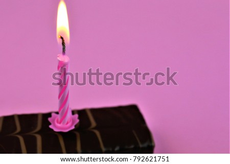 An concept Image of one candle on cake - with pink Background and copy space