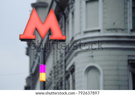 Red indicator of the Moscow Metro on the background of the building