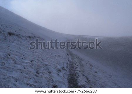 view of snowy mountain under fog and clouds in winter