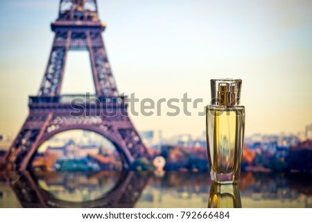 Female perfume on the background of the sights of Paris. Perfumery. Perfume on a gentle backdrop of a cityscape. Bottle with perfume.