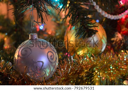 Two christmas decorations on a tree in subdued lighting