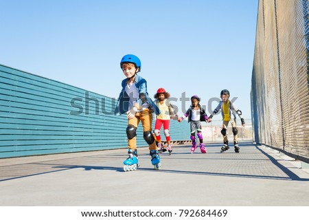 Boy playing roller skates with friends outdoors Royalty-Free Stock Photo #792684469