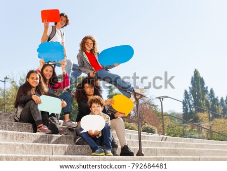 Cute teenage boys and girls holding speech bubbles