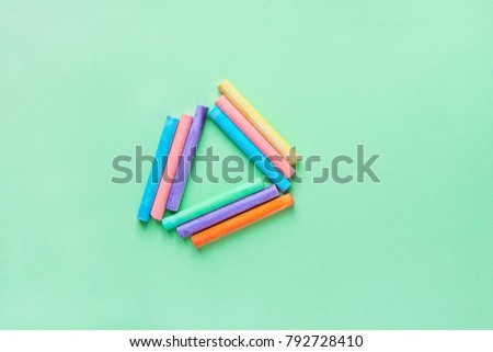 Rows of Multicolored Chalks Crayons Arranged in Triangle on Turquoise Background. Business Creativity Graphic Design Crafts Kids School Unity Concept. Copy Space